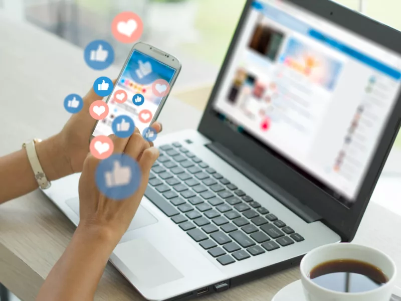 Laptop en smartphone met sociale media iconen van Facebook